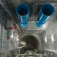 Metro Tunnel Fans A tunnel with two blue pipes hanging from the ceiling.