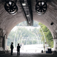 Road Tunnel Fans Two people standing in a tunnel with trees and buildings